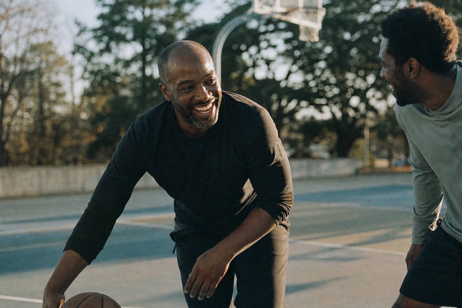 Two men laughing together during a game of basketball